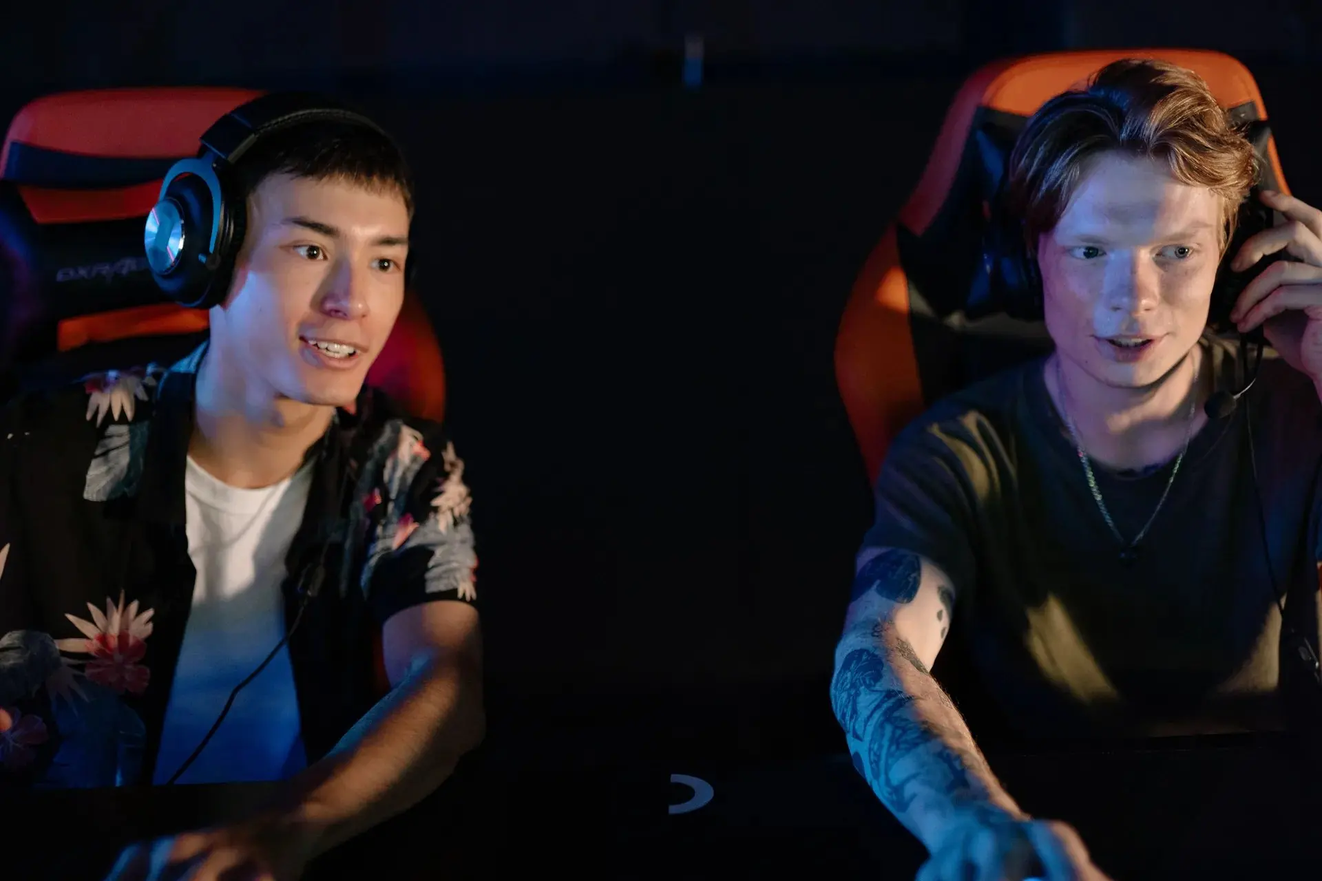People playing esports on gaming computers in a dim room